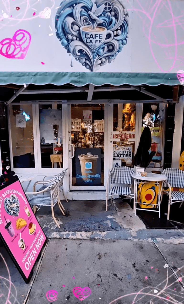 Café La Fe storefront with pink welcome sign
